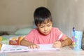 .Ã¢â¬â¹Asian child boy doing homework. He writing on a book. Kid and education concept.